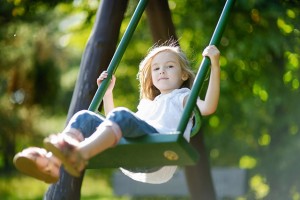 Adorable girl having fun on a swing