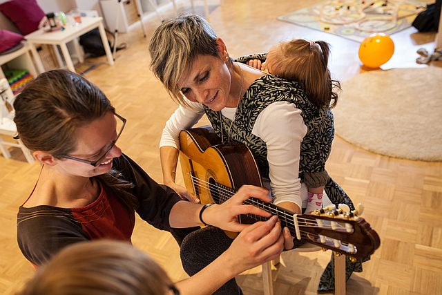 Gitarre spielen mit Baby in München