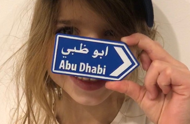 Mädchen mit Abu Dhabi-Schild