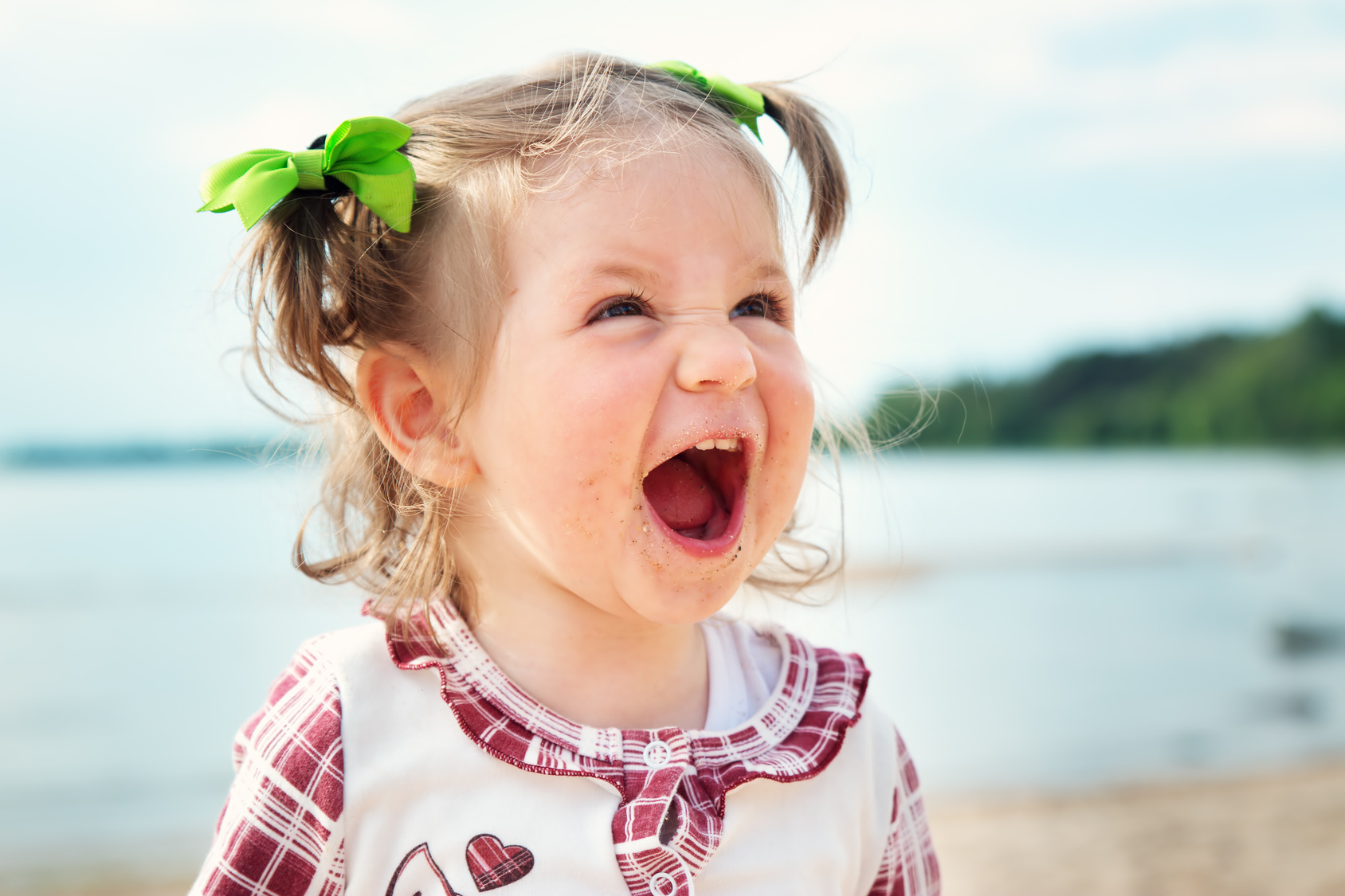 Funny little girl shouting at the sea